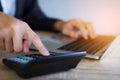 Closeup hand of business woman working with calculator and laptop for analyze report at office