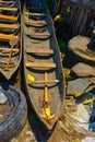 An old canoe boat between other boats and garbage, yellow oar, wooden pirogue for rafting in Africa Royalty Free Stock Photo