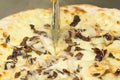 Closeup hand of chef baker cutting pizza at kitchen. Food, italian cuisine and cooking concept. Royalty Free Stock Photo