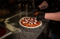 Closeup hand of chef baker making pizza at kitchen. The process of making pizza. Hands preparing a pizza Royalty Free Stock Photo