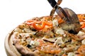 Closeup hand of chef baker in white uniform cutting pizza at kitchen Royalty Free Stock Photo