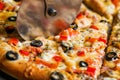 Closeup hand of chef baker in white uniform cutting pizza at kitchen Royalty Free Stock Photo