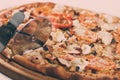 Closeup hand of chef baker in white uniform cutting pizza at kitchen Royalty Free Stock Photo