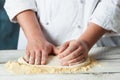 Closeup hand of chef baker in white uniform making pizza at kitchen Royalty Free Stock Photo