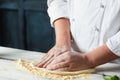 Closeup hand of chef baker in white uniform making pizza at kitchen Royalty Free Stock Photo