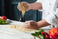 Closeup hand of chef baker in white uniform making pizza at kitchen Royalty Free Stock Photo