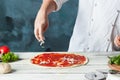 Closeup hand of chef baker in white uniform making pizza at kitchen Royalty Free Stock Photo