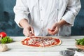 Closeup hand of chef baker in white uniform making pizza at kitchen Royalty Free Stock Photo