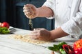 Closeup hand of chef baker in white uniform making pizza at kitchen Royalty Free Stock Photo