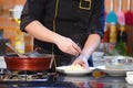 Closeup hand chef cooking spaghetti near pot pan on the gas stove in kitchen Royalty Free Stock Photo