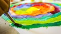 Closeup hand of child draws coloristic circle by paints on white paper. Royalty Free Stock Photo