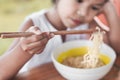 Closeup on hand of child girl holding chopstick