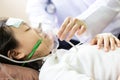 Closeup of hand female caregiver holding oxygen mask with cute child patient in hospital bed or home,little girl putting