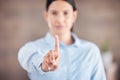 Closeup of of the hand in the foreground of a mixed race businesswoman gesturing stop or wait while standing in her Royalty Free Stock Photo