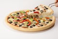 Closeup of a hand getting a slice of mouth-watering cheesy pizza isolated on a white background