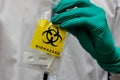 Closeup of a hand in a glove holding a self-test of Covid 19 in a plastic biohazard bag