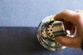 Closeup of a hand holding a barmen mixer and shaker, metal accessories on the gray background