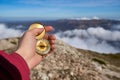 Closeup hand holding compass with mountain and clouds background. Closeup of man tourist hand holding old magnetic Royalty Free Stock Photo