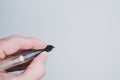 Closeup of a hand holding a fountain pen on pastel pink background with a copy space Royalty Free Stock Photo