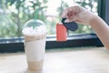 Closeup hand holding key and glass of ice cappuccino coffee on wood table  background, selective focus Royalty Free Stock Photo