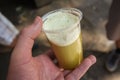 Closeup of a Hand holding sugar cane juice in a plastic cup Royalty Free Stock Photo