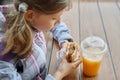 Closeup of hand of kid eating burger and drinking orange juice Royalty Free Stock Photo