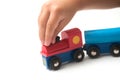 Hand of kid playing with wooden train on white background Royalty Free Stock Photo