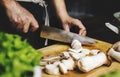 Closeup of hand with knife cutting mushroom Royalty Free Stock Photo
