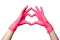 Closeup of a hand in latex rubber medical pink gloves folded into a heart sign. Isolated on white background. Concept love couple Royalty Free Stock Photo