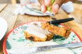 Closeup of the hand of a Latin woman seasoning a piece of chicharron with a squeeze of lime