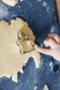 Closeup of hand of little girl baking Easter cookies at home indoors. Small child cut out bunny cookie in domestic Royalty Free Stock Photo