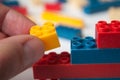 Hand of man playing with plastic bricks construction on white background Royalty Free Stock Photo