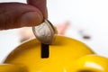 hand of man putting euro coin in yellow piggy bank o Royalty Free Stock Photo