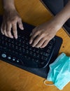 closeup of hand man typing on keyboard with medical mask to prevention during the corona virus pandemic