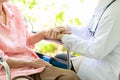 Closeup of hand medical female doctor or nurse holding senior patient hands and comforting her,.Caring caregiver woman supporting