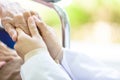 Closeup of hand medical female doctor or nurse holding senior patient hands and comforting her,.Caring caregiver woman supporting