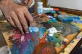 Closeup of hand mixing paint on palette at workshop Royalty Free Stock Photo