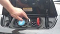 Closeup of a hand opening the coverage of a metallic car, lugging an electric car to a home charger