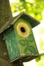 Closeup of the hand-painted wooden birdhouse hanging on the tree Royalty Free Stock Photo