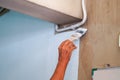 Closeup hand of the painter holding a paint brush painting white colors on the wall in renovation of old house Royalty Free Stock Photo