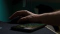 Closeup of the hand of a person using a mouse on a desk with a smartphone on it under the lights Royalty Free Stock Photo