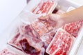 Closeup of hand picking a package of cube red meat Royalty Free Stock Photo