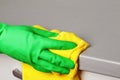 Closeup of a hand in a protective glove holding a napkin and wiping a countertop. Cleaning the kitchen Royalty Free Stock Photo