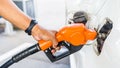 Closeup hand pumping Fuel nozzle gasoline fuel in white car Royalty Free Stock Photo