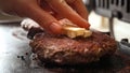 Closeup of hand putting butter on roasting beef burger patties on grill. Cooking at home, kitchen appliance, healthy nutrition,