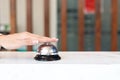 Closeup of hand ringing silver bell on hotel reception service desk, vintage bell with customer hand, check in hotel service on Royalty Free Stock Photo