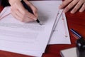 Closeup of a hand signing a last will by a pen. Royalty Free Stock Photo