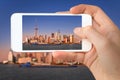 Closeup of a hand with smartphone taking a picture of Shanghai skyline and the Huangpu river China