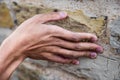 Closeup of a hand touching a weathered stone surface Royalty Free Stock Photo