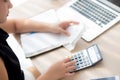 Closeup hand woman calculating expenses household and writing notebook on desk Royalty Free Stock Photo